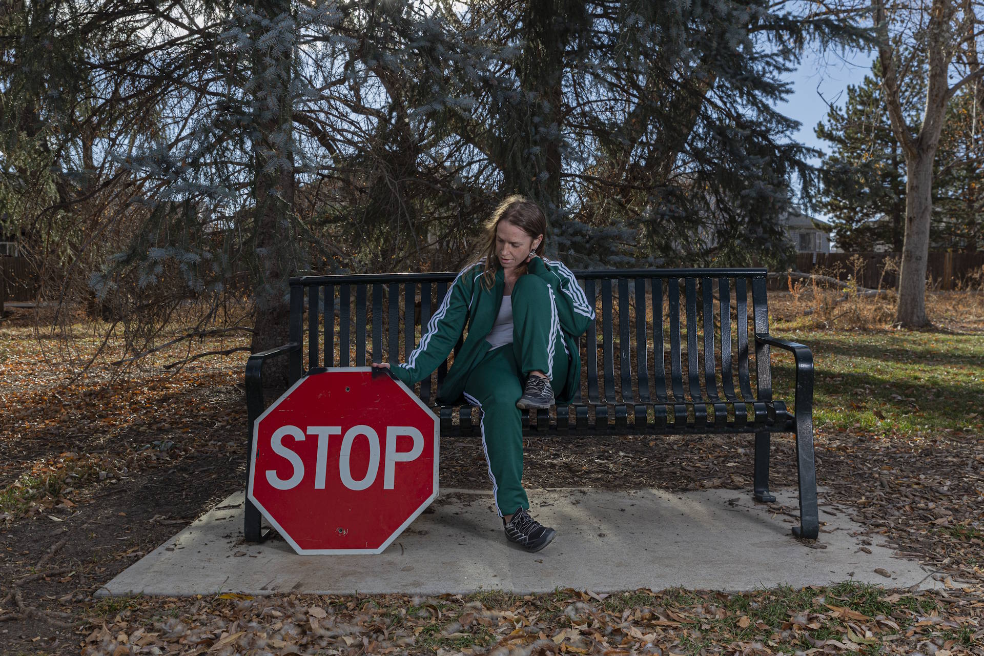 woman sitting on bench contemplating an upside down stop sign