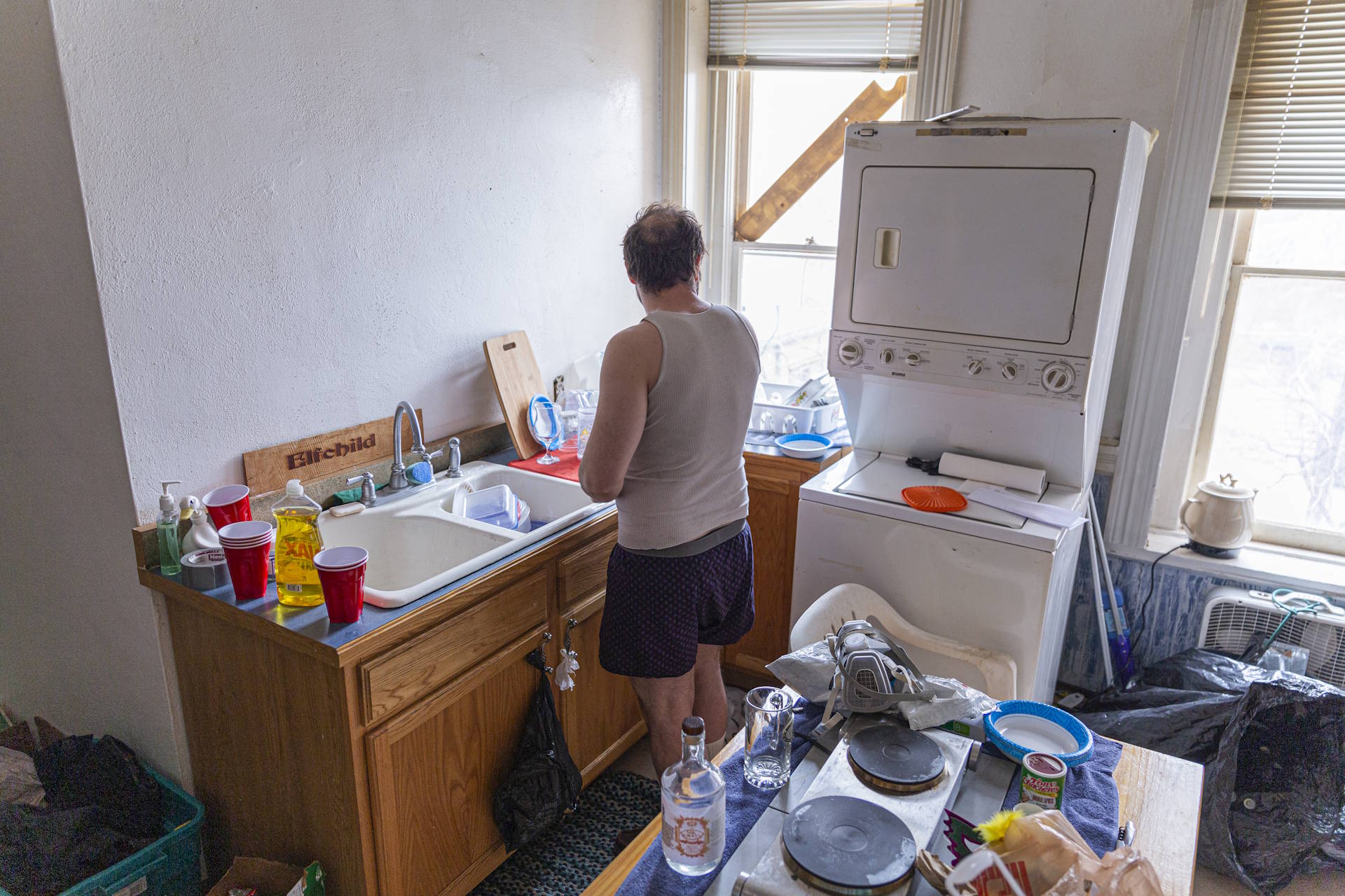 slovenly man in dirty kitchen